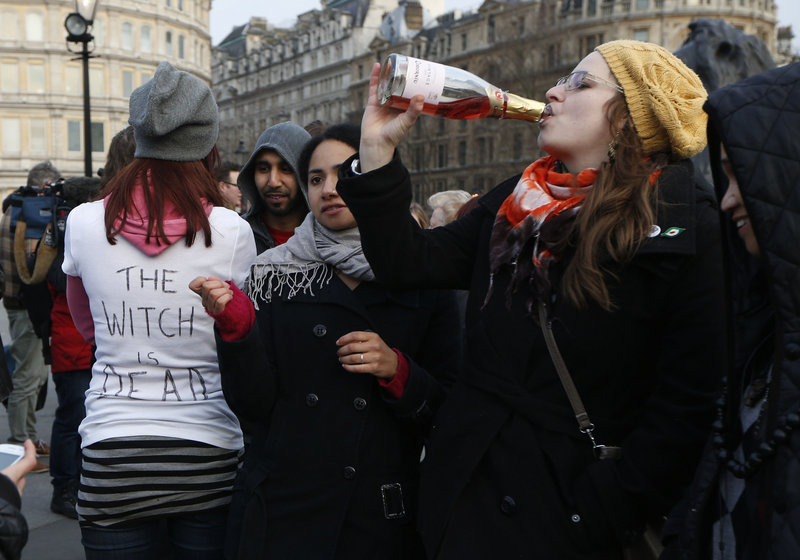Anti-Thatcher protesters react to the death of the former British prime minister in London on Monday. “The Witch is Dead” on the T-shirt refers to an anti-Thatcher song.