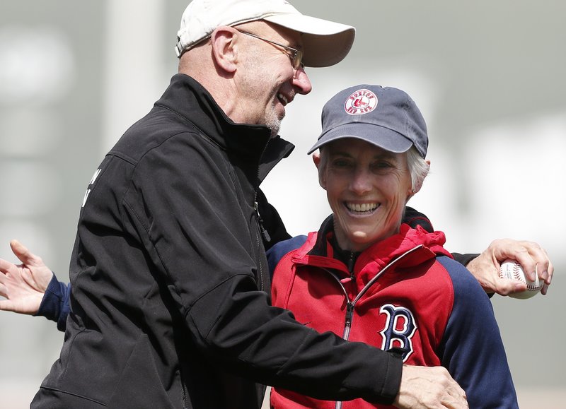 Joan Benoit Samuelson gets a hug Saturday from Greg Meyer after they threw out the first pitch at Fenway Park, celebrating the 30th anniversary of their 1983 Boston Marathon wins.