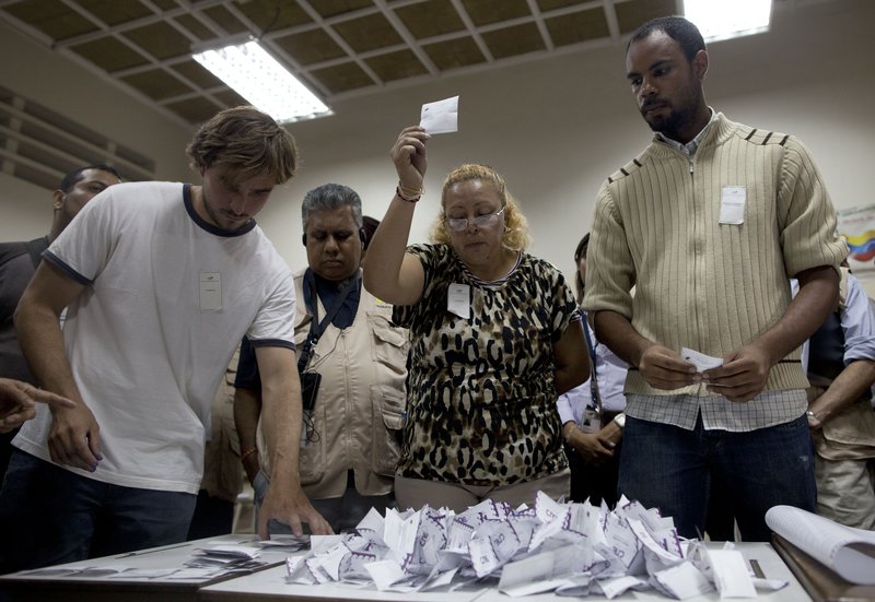 Polling workers count votes Sunday in Caracas. Millions of Venezuelans were lifted out of poverty under Hugo Chavez, but many also believe his government plundered much of the $1 trillion in oil revenues during his tenure.