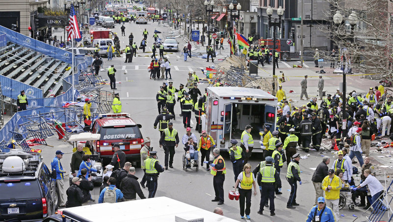 Emergency responders tend to injured people at the finish line of the Boston Marathon after Monday’s explosions. Three people were killed and more than 140 were injured.