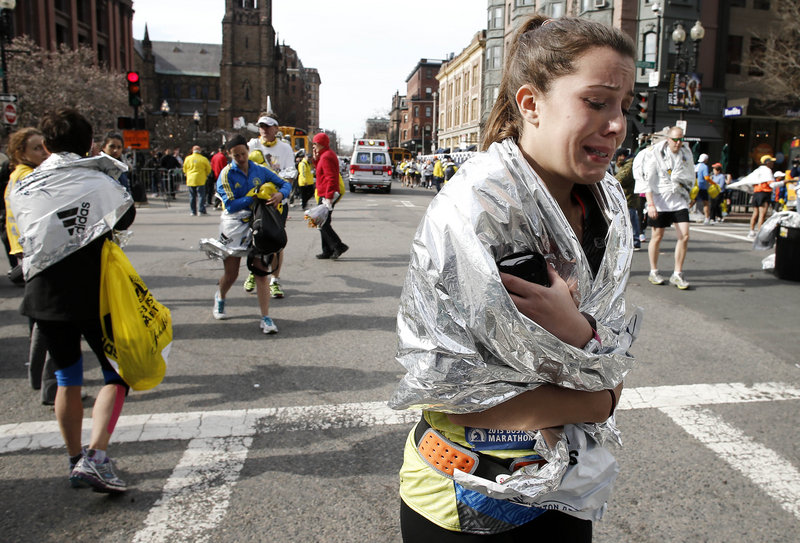 A Boston Marathon runner cries as she leaves the course near Copley Square on Monday.