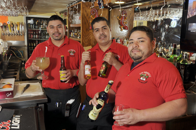 Manager Gama Chavez with staff members Juan Lozano and Ocho Chavez display some of the drink options at Los Tapatios on Adams Street in Biddeford, including the large margarita.