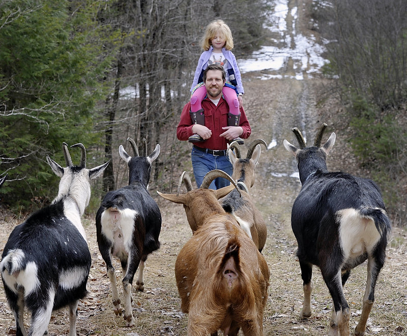 Karl Schatz, with 4-year-old daughter Beatrice, prepares the animals for the last leg of a hike up the hill behind him.