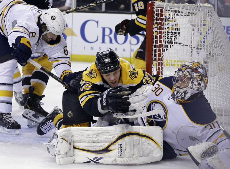 Boston right winger Shawn Thornton (22) falls onto Buffalo goalie Ryan Miller while defenseman Mike Weber (6) lunges for the puck Wednesday night in Boston.