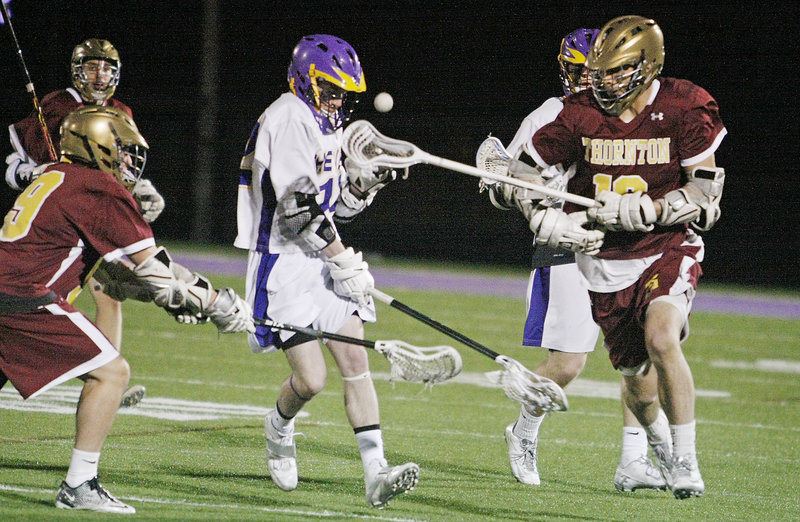 Hilmar Smith of Cheverus, left, tries to avoid the stick and the ball Wednesday night as Taylor Browne of Thornton Academy attempts to gain control during Cheverus’ 7-3 victory in a schoolboy lacrosse game.