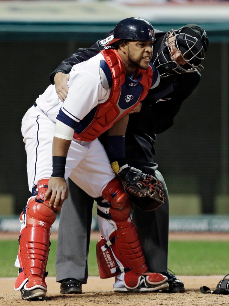 Umpire Tim Timmons tends to Cleveland catcher Carlos Santana after he was hit by a foul tip off the bat of Boston’s Dustin Pedroia in the fourth inning Wednesday night.