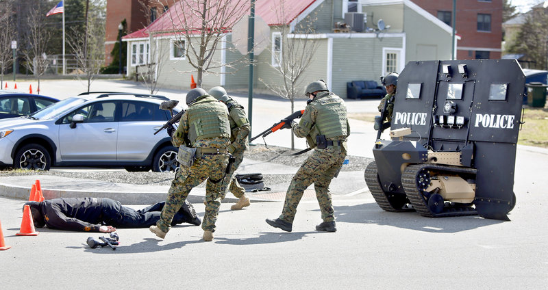 Members of the Southern Maine Special Response Team approach a "suspect" after being shot with paint balls during a demonstration of the "SWAT Bot" at the Sanford Police Department on April 18, 2013. The "Swat Bot", built by Howe and Howe Technologies, is the world's first remote tactical approach vehicle.