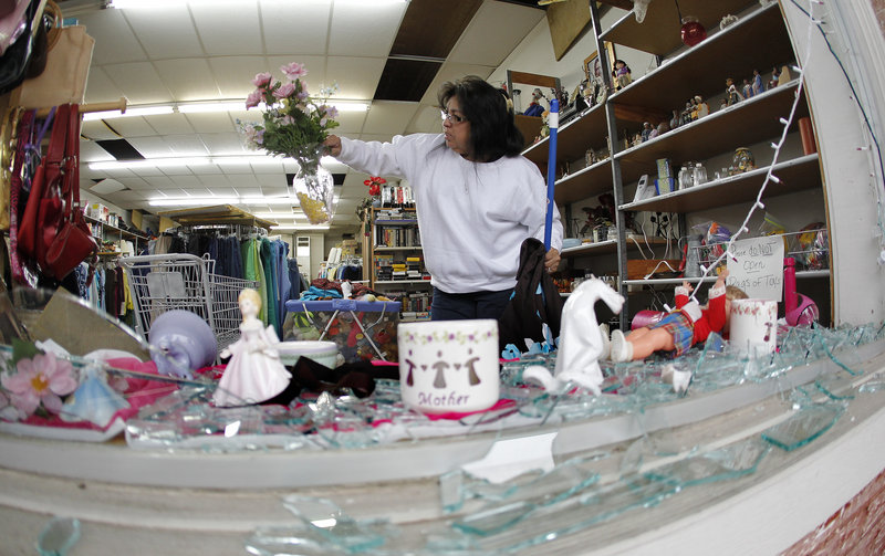 Maria Galvan sorts through damaged merchandise inside the West Thrift Shop on Thursday.