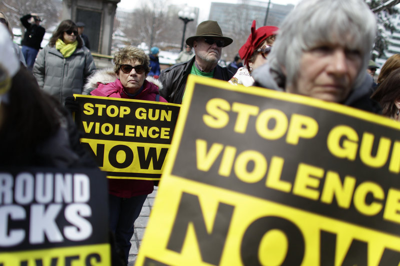Supporters of gun control measures hold signs on the steps of the Colorado State Capitol in Denver on Thursday during a rally to honor U.S. victims of gun violence since the 1999 Columbine High School shooting.