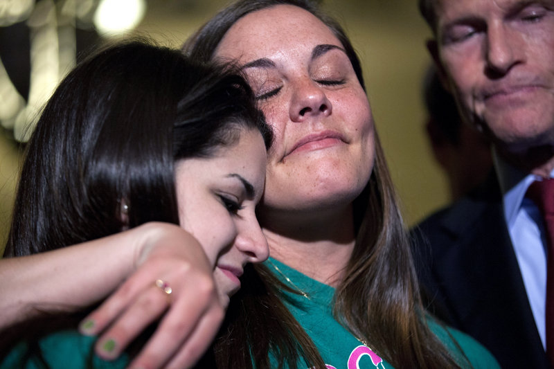 Carlee Soto, left, sister of Sandy Hook teacher Victoria Soto, and Erica Lafferty, daughter of Sandy Hook Principal Dawn Hochsprung, embrace outside the U.S. Senate chamber Wednesday after a vote on gun control legislation. A proposal to require background checks on almost all gun sales is now before the Maine Legislature.