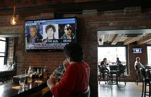 Customers watch the news at the Granary Tavern in Boston on Friday. Two suspects in the Boston Marathon bombing killed an MIT police officer, injured a transit officer in a firefight and threw explosive devices at police during their getaway attempt in a long night of violence that left one of them dead and another still at large Friday.