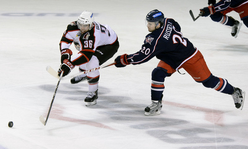Brandon Gormley of the Portland Pirates battles for the puck against Ryan Russell of the Springfield Falcons on April 7.