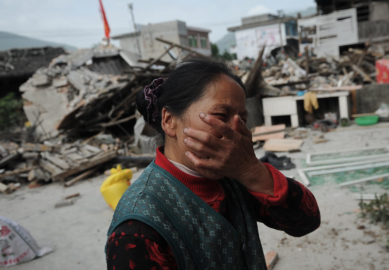 A village woman reacts after her house was damaged by the earthquake in Ya’an, also in Lushan county. The quake triggered landslides and disrupted phone and power connections in the mountainous area.