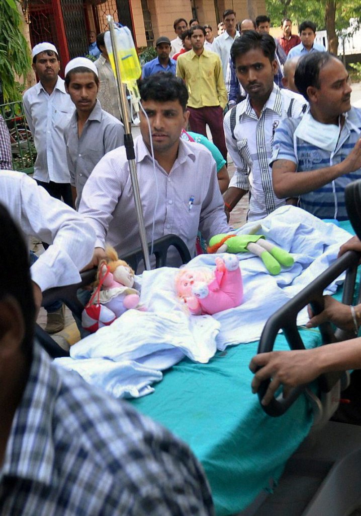 Stuffed toys lie with a 5-year-old girl being wheeled into a hospital for treatment Friday after she was raped and tortured by a man in India’s capital of New Delhi.