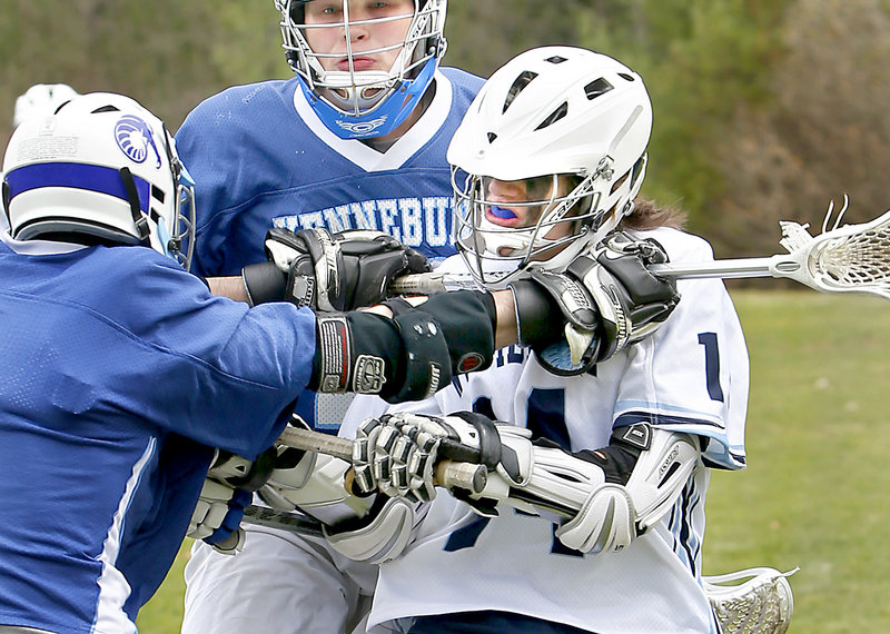 Jesse Shields, left, of Kennebunk uses his stick to harass Tyler Jack of Westbrook during Saturday’s lacrosse game in Westbrook. Kennebunk cruised to a 12-1 victory.