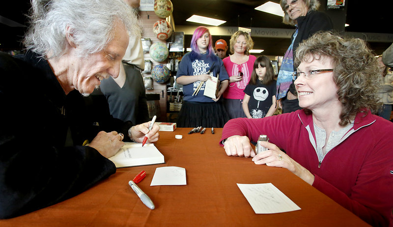 John Densmore signs a copy of his book, “The Doors Unhinged,” for Leslie Bruenn of Cobalt, Conn., at Bull Moose. She and her husband, Carl Bruenn, were the first ones in line, at 9 a.m. for the 2 p.m. event.