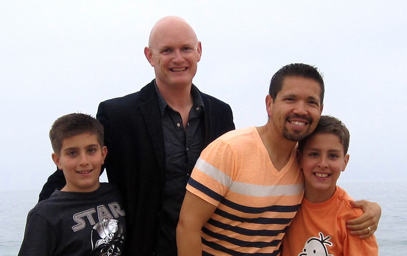 Kevin Covey, center left, and his husband, Joseph, stand with their twin 9-year-old sons Austin, left, and Dakota in Newport Beach, Calif. The federal government doesn’t recognize the men’s marriage under the 1996 Defense of Marriage Act, under review by the Supreme Court.