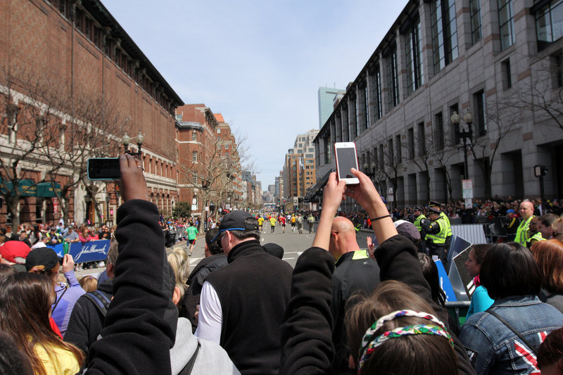 Spectators take photos with camera phones during the Boston Marathon on Monday, before two bombs exploded at the finish line in an attack that killed three people and wounded more than 180.