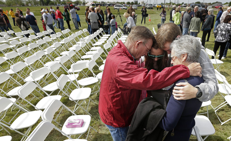 Churchgoers huddle to pray after a service of the First Baptist Church in a field Sunday, four days after an explosion at a fertilizer plant in West, Texas. The congregation could not meet in the church building because it is in the damage zone.