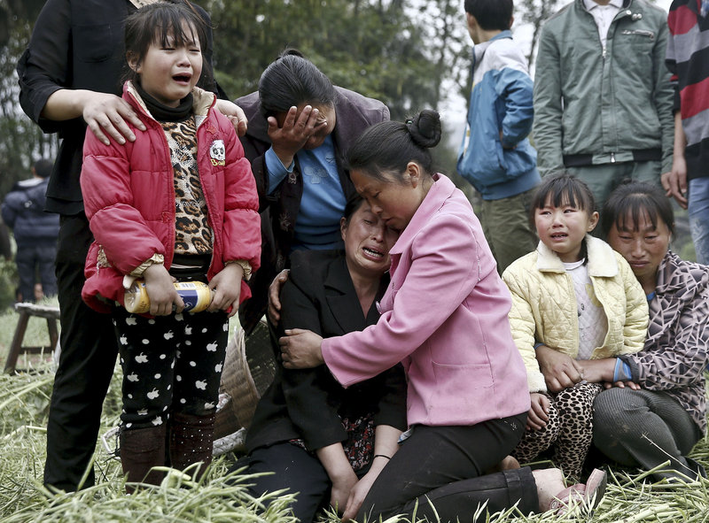 Villagers attending a funeral in Longmen village in Lushan county in southwest China’s Sichuan province Sunday cry for their relatives who were killed in an earthquake.