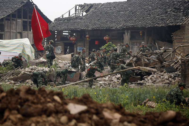 Rescue workers in Qingyan village in southwestern China’s Sichuan province search Monday through the rubble of a building that collapsed during Saturday’s earthquake.