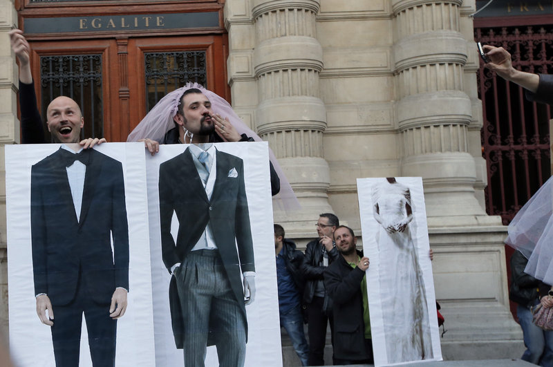 Divisive issue: While pro-gay marriage activists in Paris playfully pose in support of thieir cause, the legalization of same-sex marriage also spurred hundreds of thousands to protest in France’s capital. Famous for embracing love and romance, the people of France are not united on this issue.