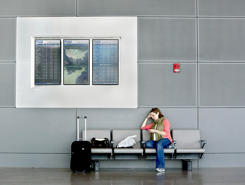 Lauren Messner of New York City waits for her delayed flight home at the Portland International Jetport on Monday afternoon. Messner said she was told when she checked in that her flight was delayed for one hour because of the air traffic controller cutbacks.
