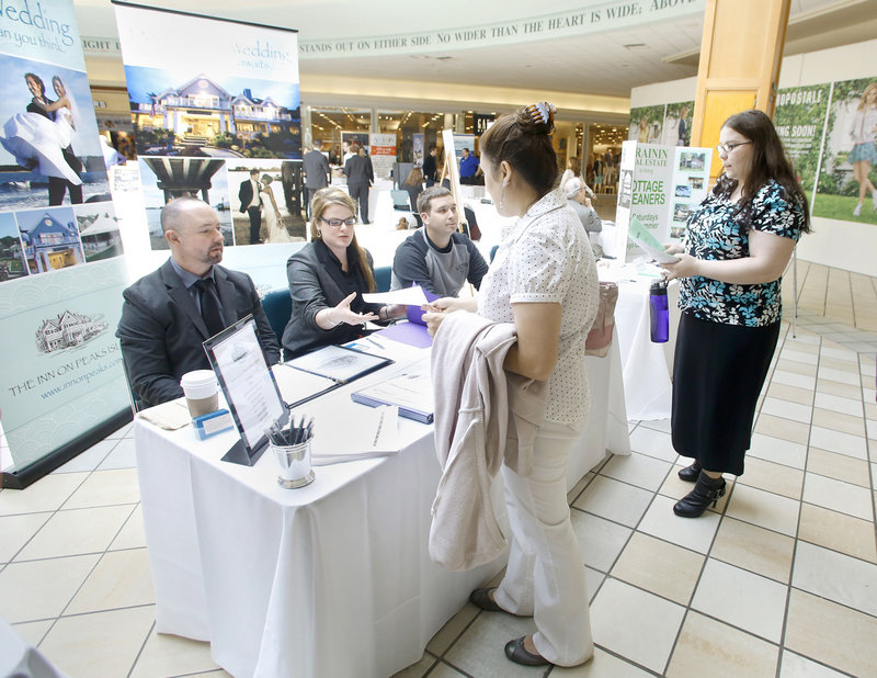 Ashley Dombrowik of Saco gives her application to Amanda Conley of The Inn on Peaks Island, as another applicant waits, at the job fair at the Maine Mall Wednesday. With Conley from the inn are Jayson Mathieu, left, and Andrew Hobin.