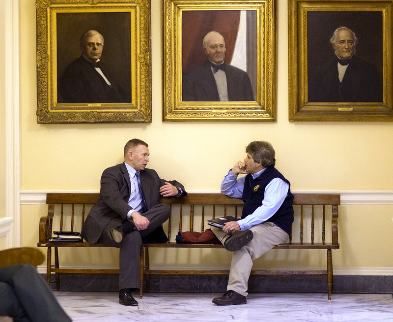 Maj. Christopher Grotton of the Maine State Police, left, speaks with David Trahan, executive director of the Sportsman’s Alliance of Maine, about gun issues in a hallway at the State House in Augusta last Wednesday.