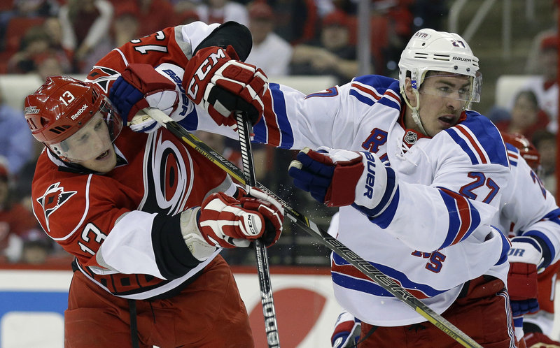 Carolina’s Jared Staal, left, jousts with the New York’s Ryan McDonagh during second-period action of Thursday’s game in Raleigh, N.C., won by the Rangers.