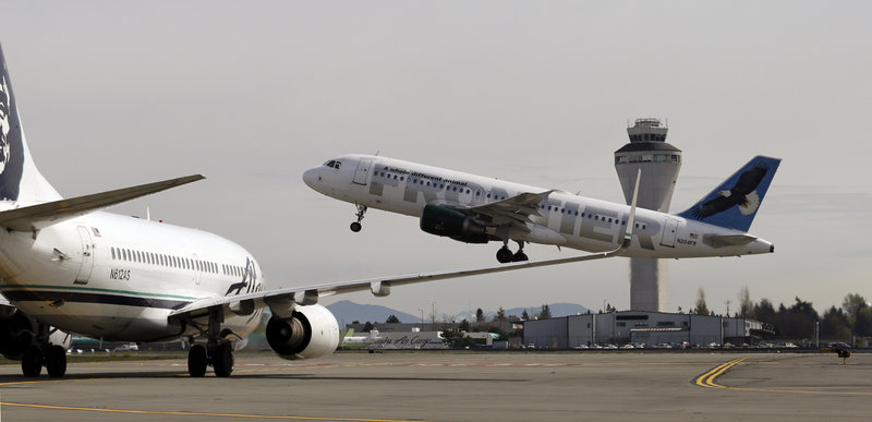 One jet departs in view of the air traffic control tower at Seattle-Tacoma International Airport as another waits on the tarmac Tuesday. The bill permits the Transportation Department to transfer $253 million from other parts of the agency.