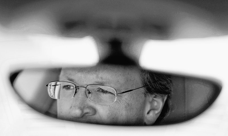 Mike Quincy, automotive specialist at Consumer Reports, is reflected in a rear-view mirror while giving a tour.