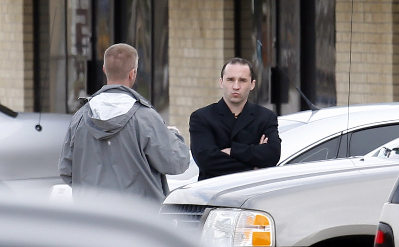Everett Dutschke, right, confers with a federal agent Wednesday near the site of a martial arts studio he once operated in Tupelo, Miss. Dutschke was arrested Saturday.