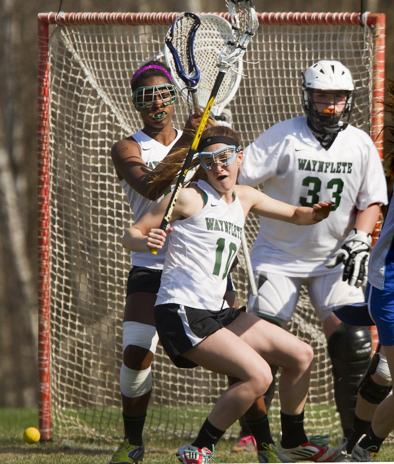 Amelia Deady of Waynflete keeps her focus on a loose ball while continuing to help defend the net in front of goaltender Katherine Torrey.