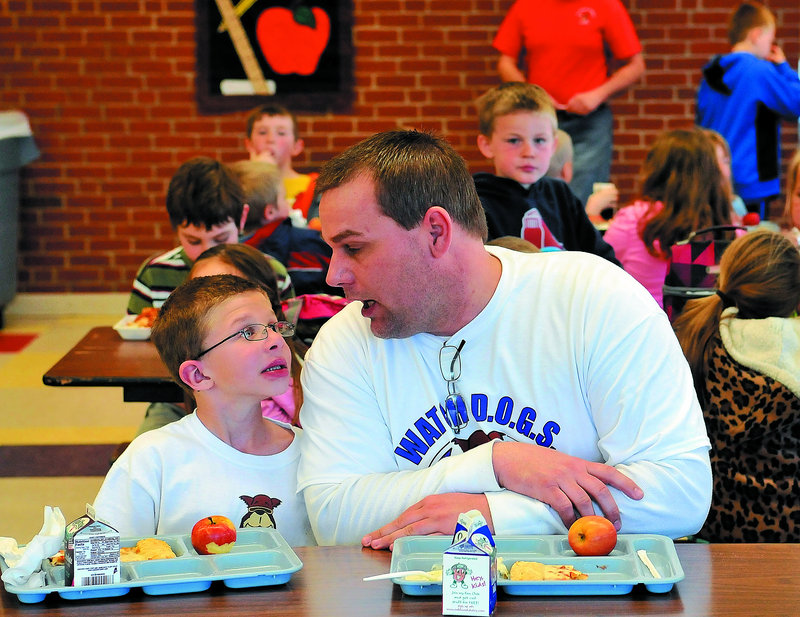 Todd Atwood, a volunteer Watch Dog at Belgrade Central School, sits with his son Luke, 8, during lunch Thursday.