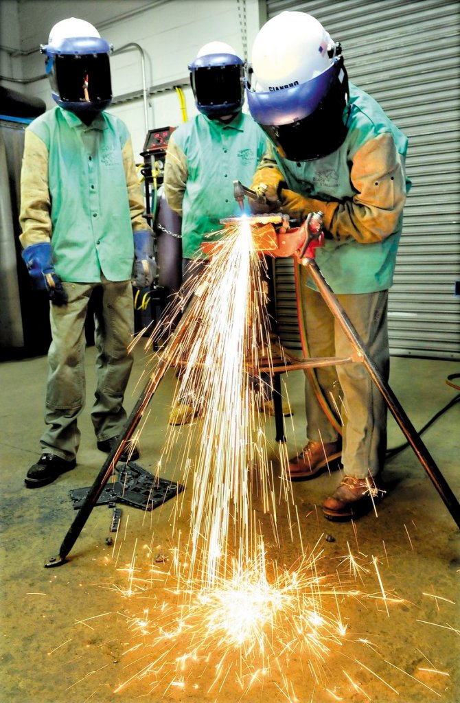 Sarah Finnemore uses a cutting torch to cut steel at the Cianbro company welding training center in Pittsfield.