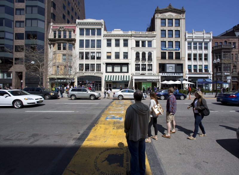 People pause on Boylston Street at the finish line of the Boston Marathon last Saturday. A pedestrian who strolls through Boston’s Financial District can be seen by at least 233 private and public cameras.