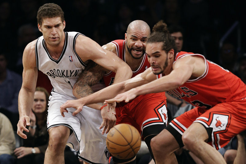 Brooklyn center Brook Lopez, left, Chicago forward Carlos Boozer and center Joakim Noah lunge at a loose ball during Monday’s game in New York.
