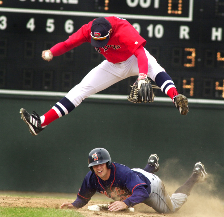 Staff Photo by Jill Brady, Sunday, April 18, 2004: Sea Dogs short stop #14, Kenny Perez, jumps over Mets #23, Chris Basak, after making the first out of the second inning during Sunday's game at Hadlock Field in Portland. Jill Brady Baseball
