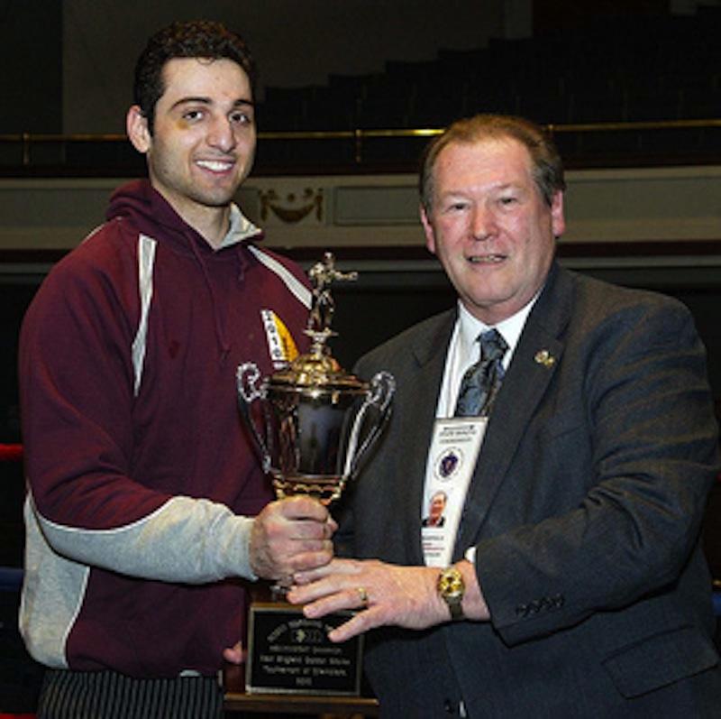 Tamerlan Tsarnaev, left, is shown accepting the trophy for winning the 2010 New England Golden Gloves Championship from Dr. Joseph Downes in Lowell, Mass., on Feb. 17, 2010. Authorities are trying to determine whether the now-dead Boston bombing suspect had a hand in the unsolved triple slaying of Tsarnaev's boxing partner.