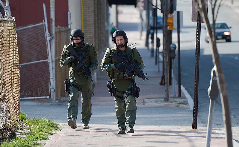 SWAT team members make their way up Preble Street in Portland during a standoff on Alder Street on Monday.