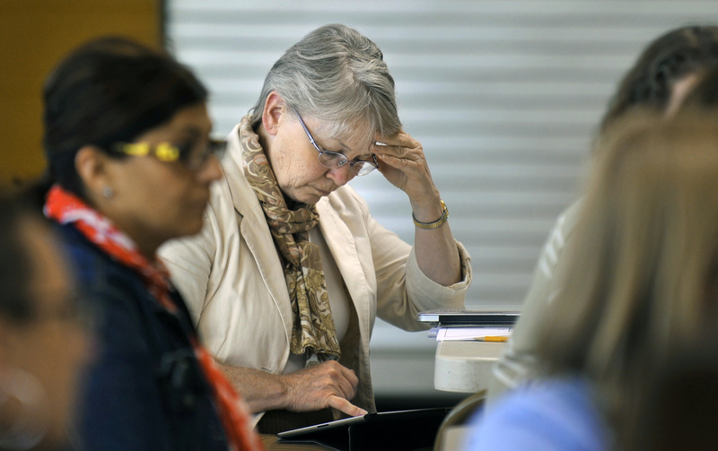 Susie Winslow, a teacher at the East End Community School, studies the report card the state gave the school during a staff meeting Wednesday. The state gave the school an F.