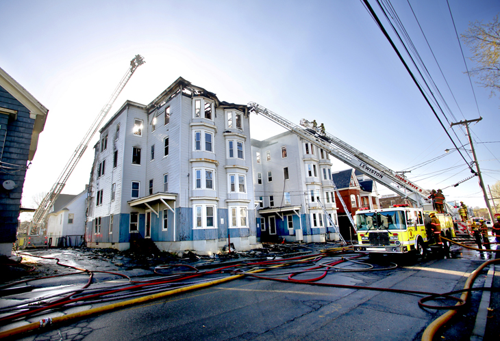 Firefighters work at the scene of a fire that destroyed two vacant apartment buildings on Bartlett Street in Lewiston on Monday morning. Fire Chief Paul LeClair said it took firefighters nearly four hours to bring the flames under control.