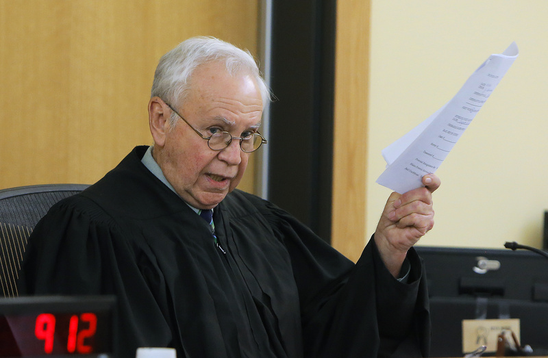 Judge John Beliveau holds a copy of an affidavit from defendant Brian Morin during Moran's arraignment Monday in Lewiston District Court on three counts of arson.