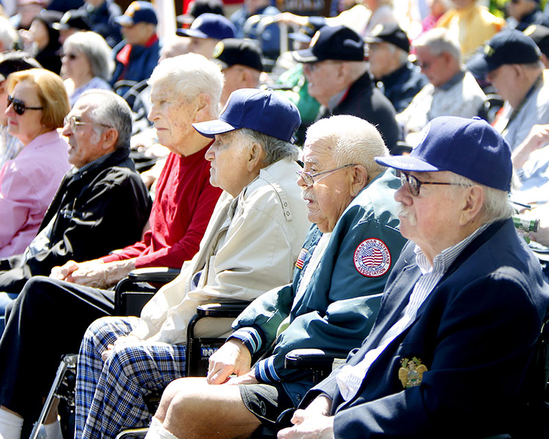 Maine Veterans’ Home residents, many in wheelchairs, watch the Scarborough Memorial Day ceremony Monday morning.