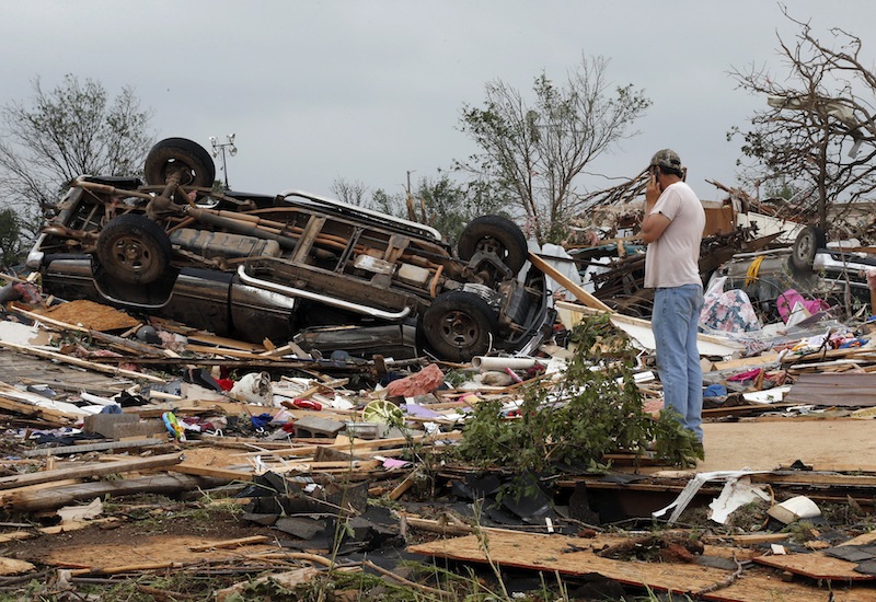 John Warner surveys the damage near a friend's mobile home in the Steelman Estates Mobile Home Park, destroyed in Sunday's tornado, near Shawnee, Okla., Monday, May 20, 2013. (AP Photo Sue Ogrocki)