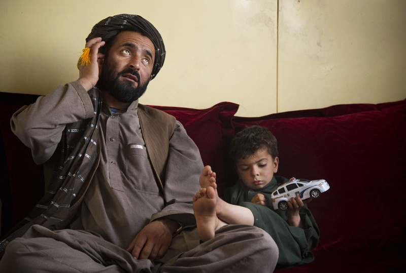 Mohammed Wazir sits with his only surviving son, Habib Shahin, 4, in Kandahar, Afghanistan, in April as he talks about the events of March 11, 2012, when a U.S. soldier burst into his family's home. Wazir returned to his home that morning to find 11 members of his family dead, their bodies partially burned. The youngest among the dead was his 1-year-old daughter Palawan Shah.