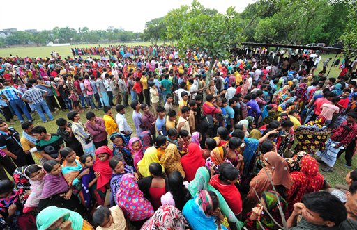 Garment workers employed at Rana Plaza, the garment factory building that collapsed, queue up to receive wages from the Bangladesh Garment Manufacturers and Exporters Association in Savar, Bangladesh.