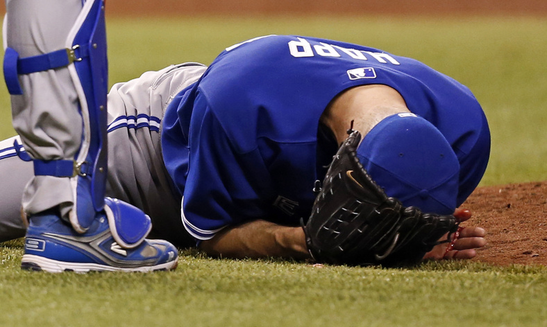 Toronto Blue Jays starting pitcher J.A. Happ holds his head after being hit in the head by a line drive from Tampa Bay Rays' Desmond Jennings during the second inning of a baseball game Tuesday in St. Petersburg, Fla.