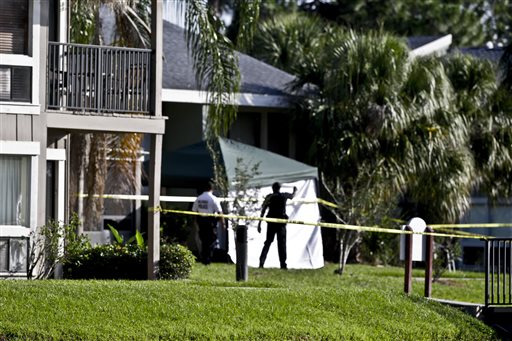 Investigators stand outside an apartment complex where a man was fatally by an FBI agent early Wednesday in Orlando, Fla.
